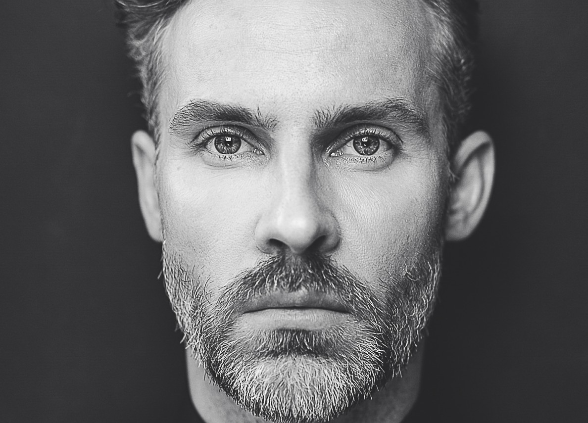 Portretowe zdjęcie aktora Bartosza Porczyka.